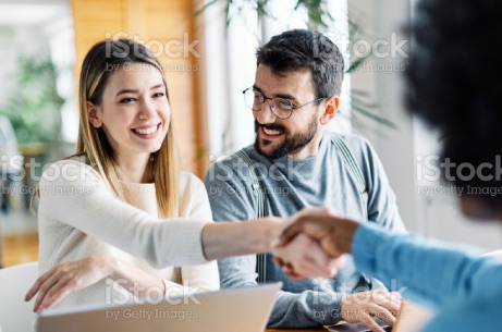 Real estate agent with couple shaking hands closing a deal